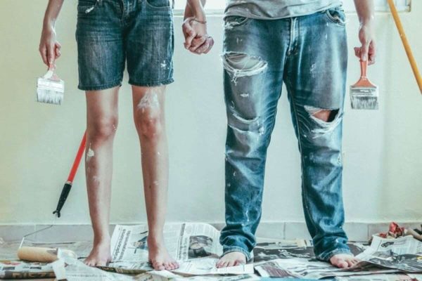 Couple painting their home together while using home renovation loans to fund improvement costs.