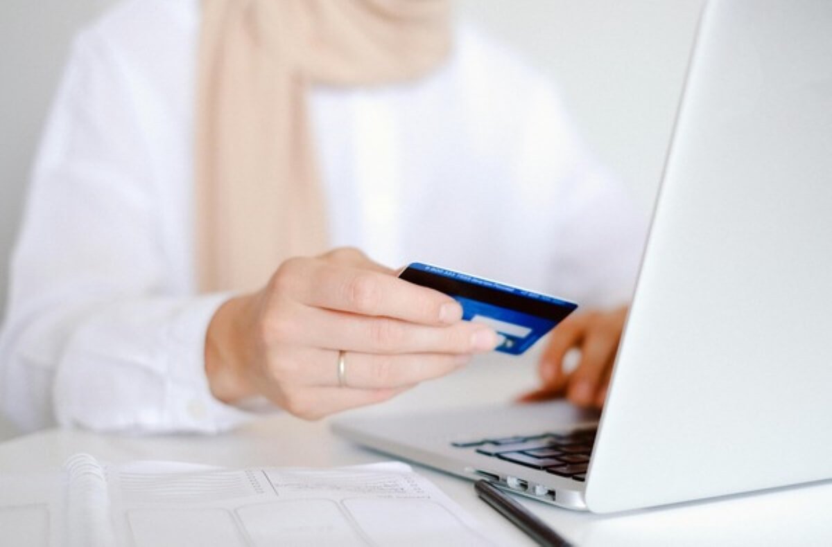 Person making an online credit card payment on a laptop as part of managing student loans and repayment and other financial commitments.