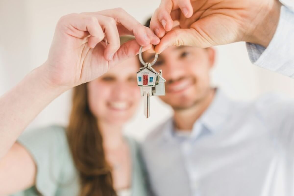 Couple receiving house keys after purchasing their home, representing the final step after choosing an HDB loan and a bank loan.