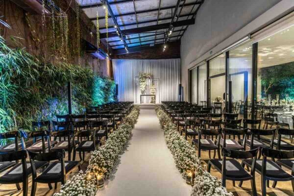 Elegant indoor ceremony aisle with lush greenery and floral arrangements at one of the modern wedding venues in Singapore.