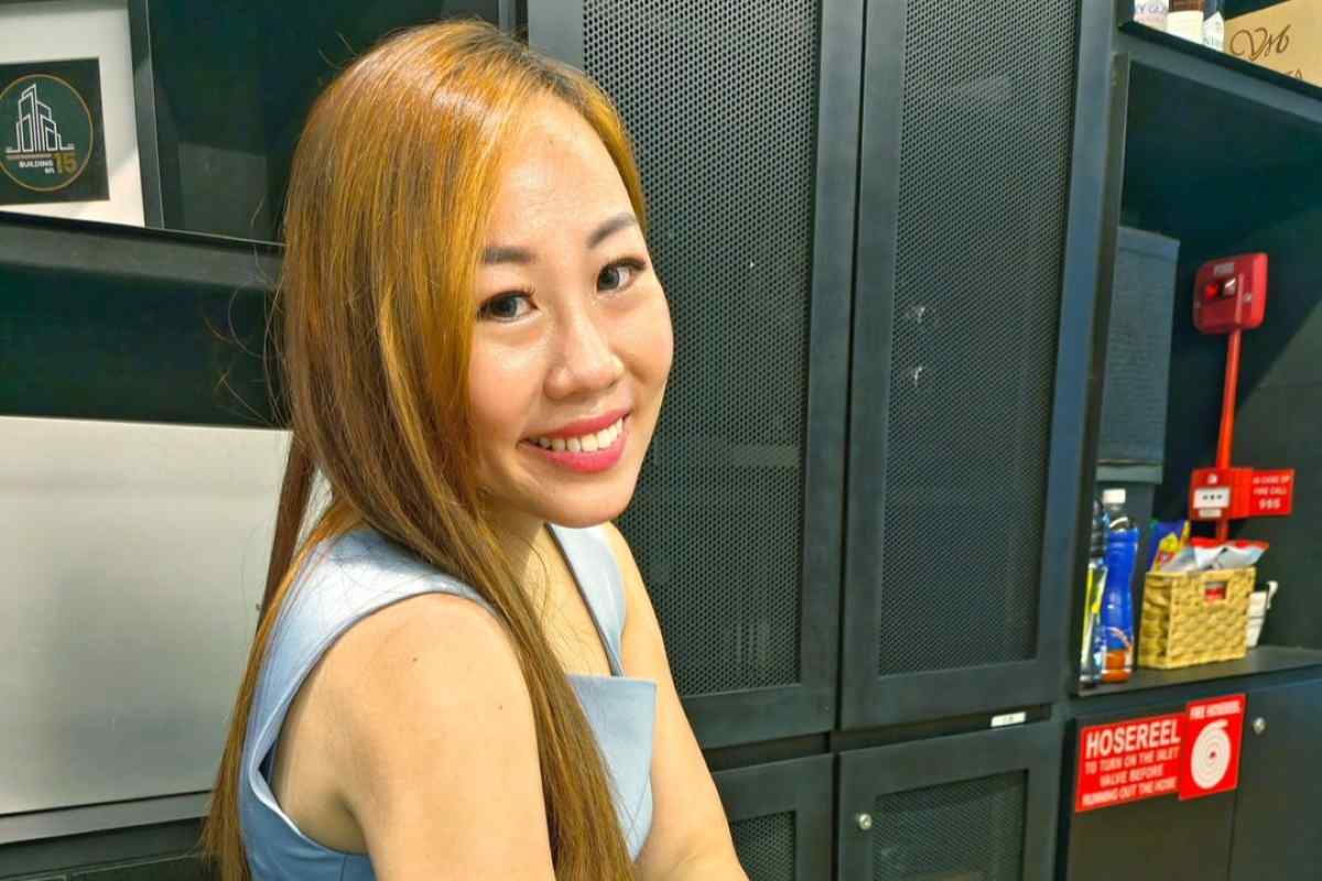 Finance content creator smiling in a workspace while creating educational money content.