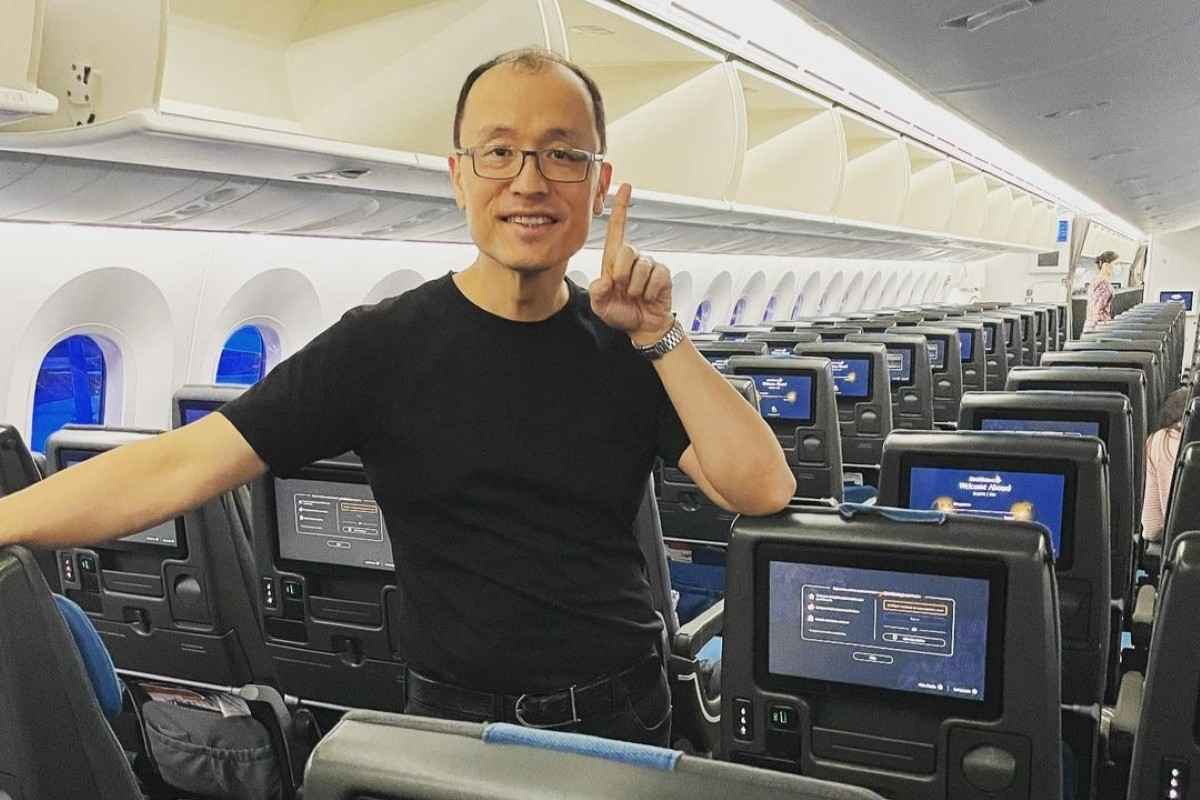 Finance content creator posing inside an aeroplane cabin while sharing travel and money insights.