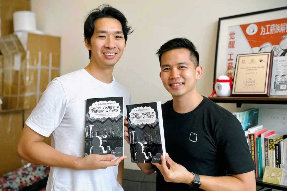 Two finance content creators holding a personal finance book during a discussion on money and investing.