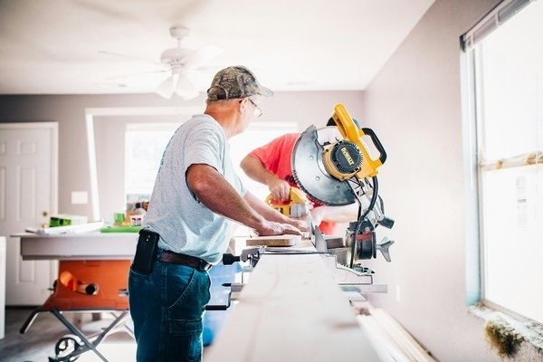 Two men using miter saw