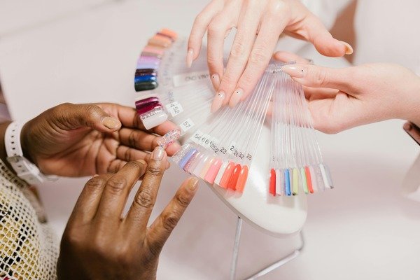 Two person choosing a nail color from nail color palette