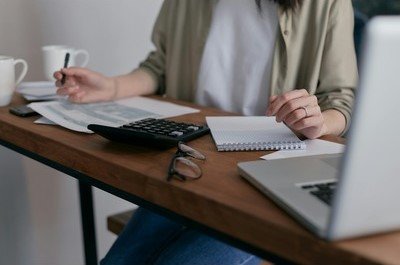 A person calculating and writing on top of a table