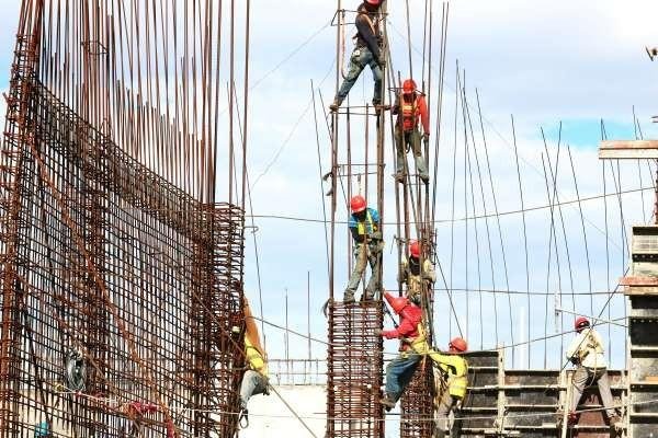 Construction workers on a building site, illustrating the migrant workers new medical insurance rules for workplace healthcare coverage in Singapore.
