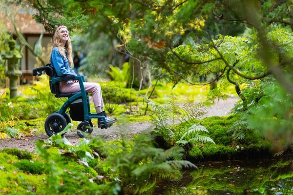 Woman using a wheelchair in a peaceful garden, illustrating how CareShield Life supports individuals with severe disability and long-term care needs.