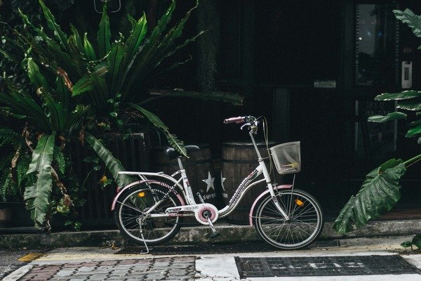 A silver bicycle at the side of the road