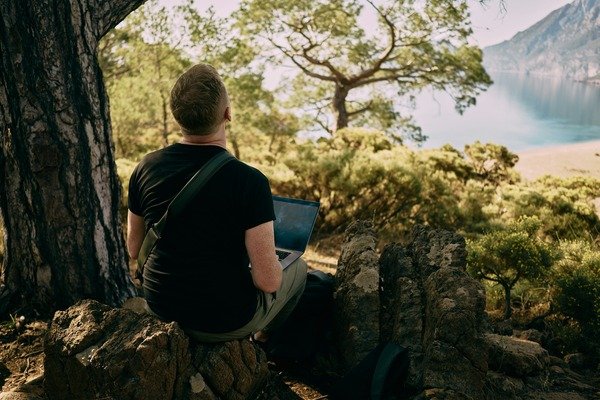 A person sightseeing with a laptop on his lap.