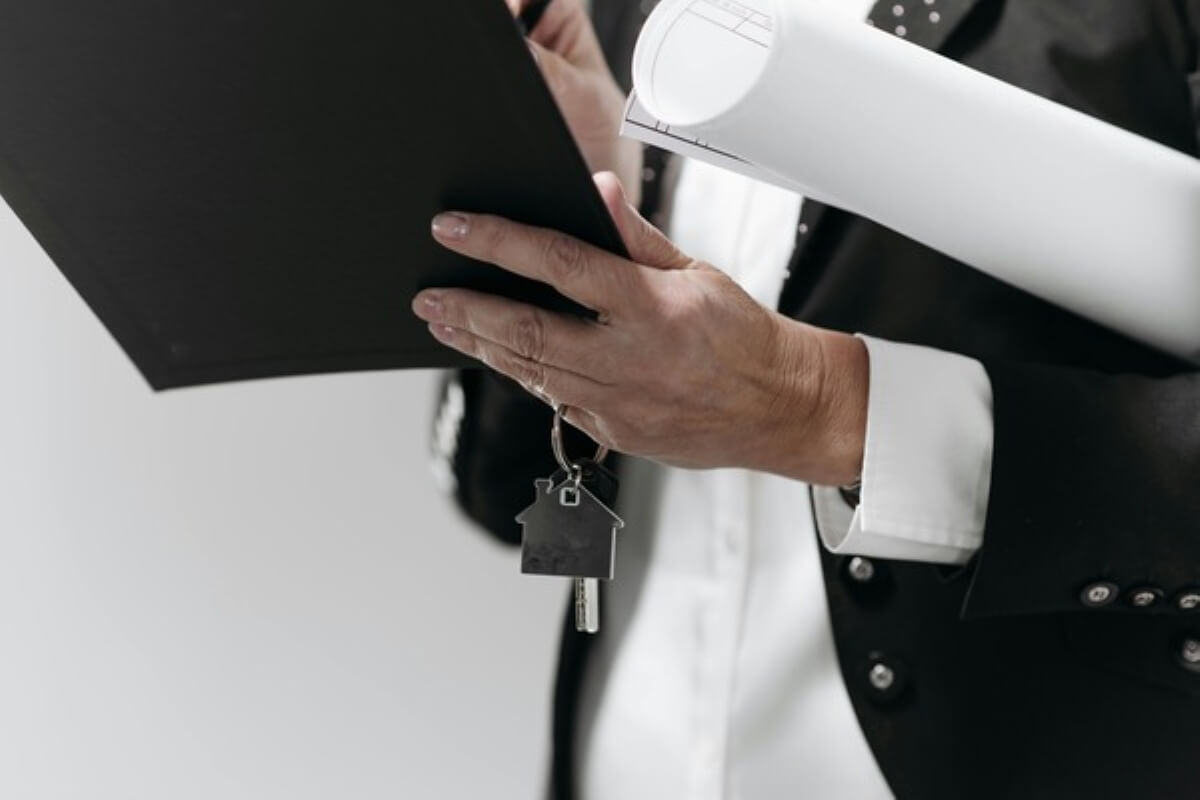 Property agent reviewing documents and handing over house keys after buying property in Malaysia.