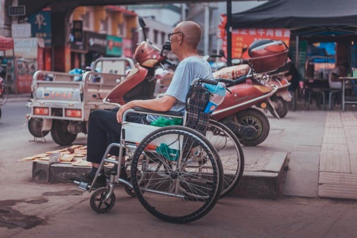 Wheelchair user navigating a public street, highlighting the financial protection offered by disability income insurance after a disability.