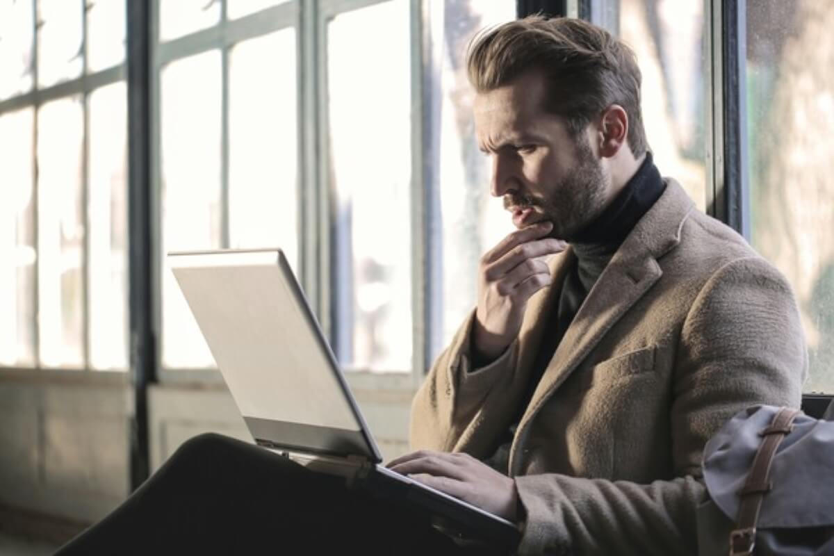Professional researching insurance plans on a laptop, evaluating the differences between MINDEF SAF and term life insurance for long-term protection.