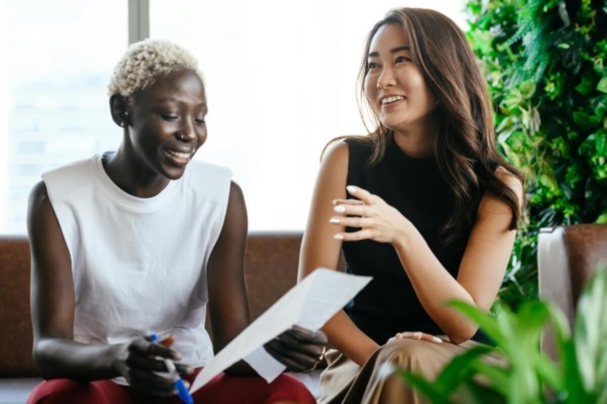 Two people reviewing insurance documents together before buying insurance through an adviser.