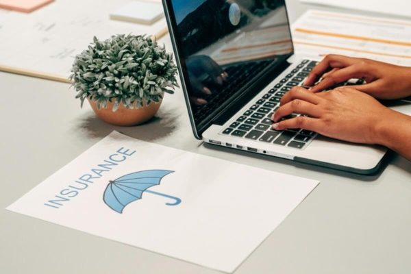 Laptop displaying insurance documents during online research for buying insurance.