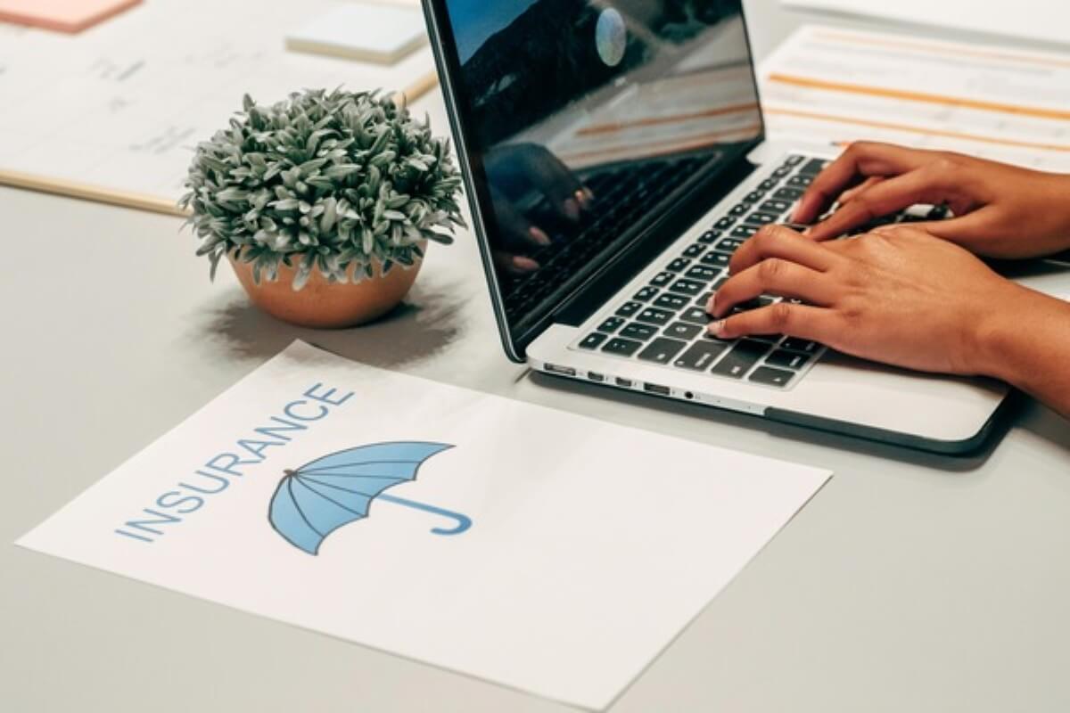 Laptop displaying insurance documents during online research for buying insurance.