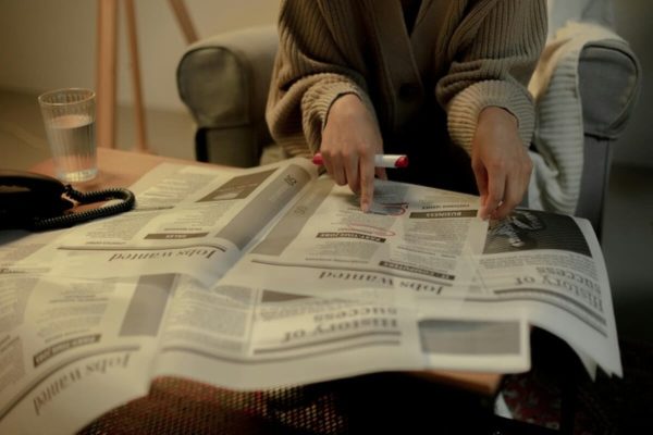 Person reviewing job listings and highlighting opportunities while planning a midlife career change.