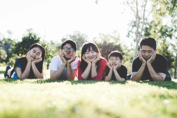 Multi-generational family relaxing together in a park, representing legacy planning and the transfer of wealth and values.