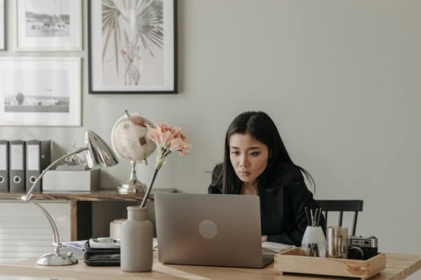 Entrepreneur working from a home office, planning strategies to grow your side hustle into a business with sustainable income.