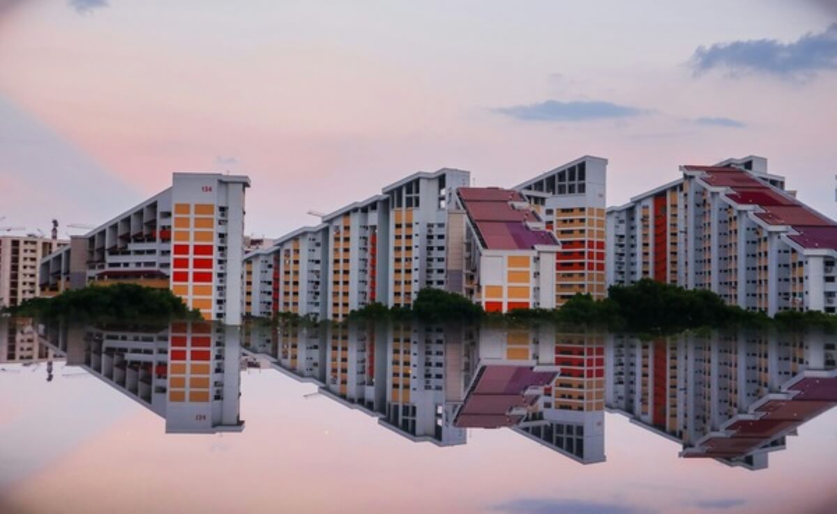 Singapore HDB blocks reflected in water, representing mortgage loan insurance for public housing homeowners.