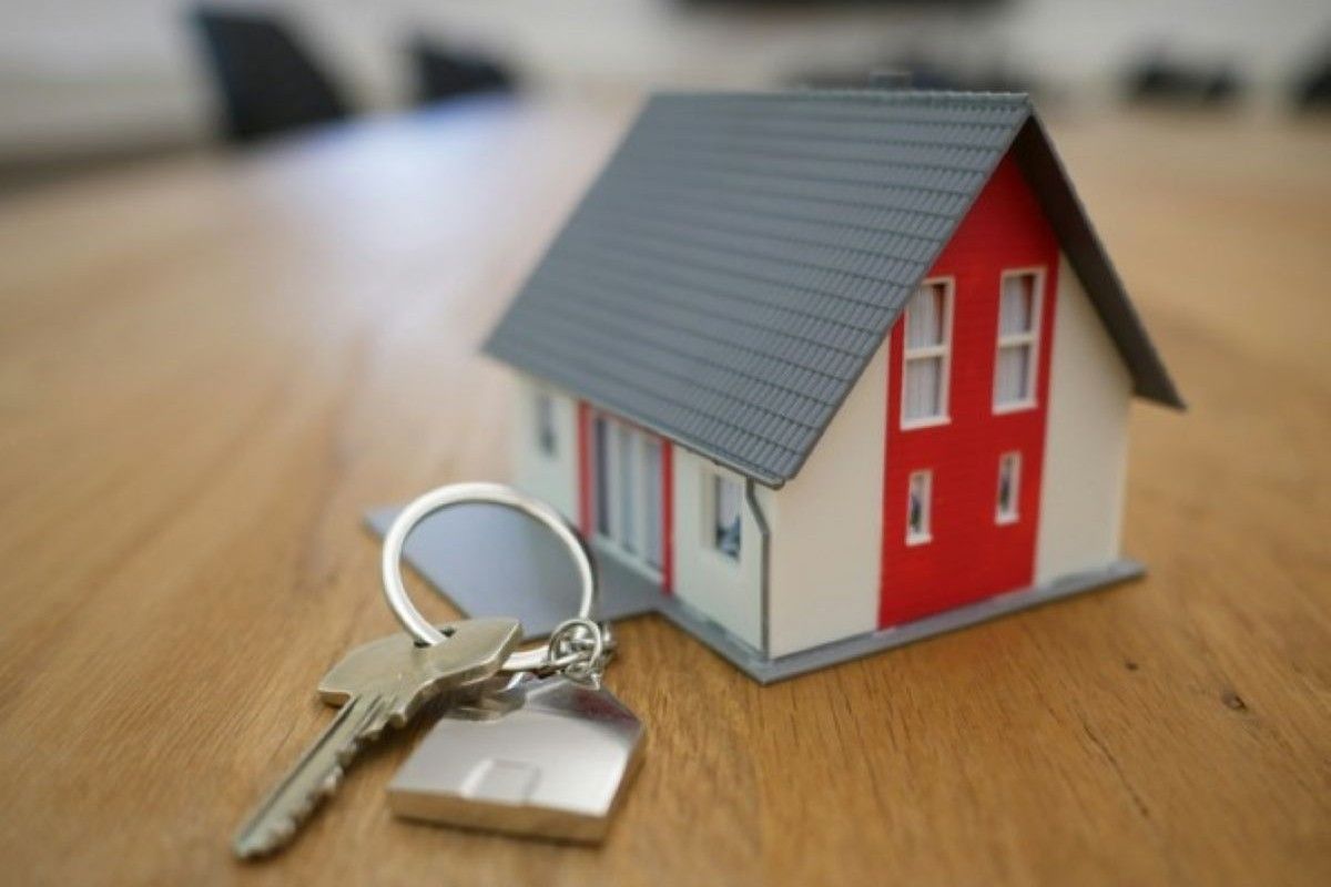 Model house and keys on a table, symbolising mortgage loan insurance that helps protect a family’s home loan.