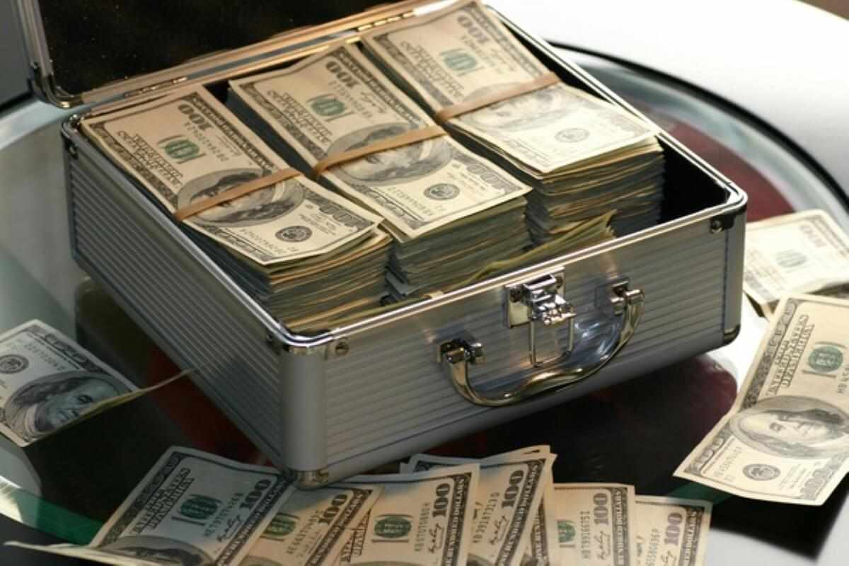 Briefcase filled with cash, symbolising the pursuit of wealth and money lessons about balancing ambition with financial responsibility.