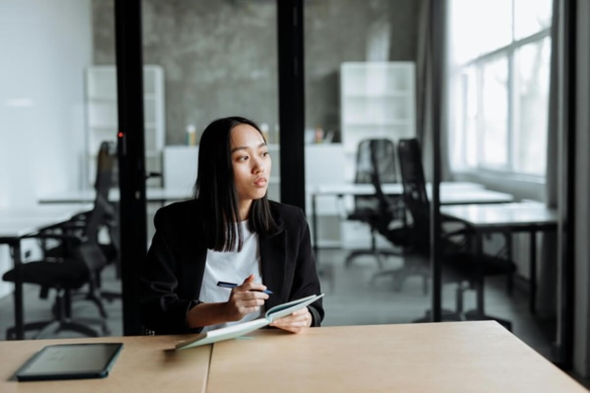 Professional reflecting in an office with a notebook, highlighting thoughtful financial planning and money lessons for long-term success.