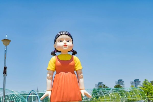 Young-hee doll from Squid Game standing outdoors, symbolising risky financial decisions and the money lessons viewers can learn from the series.