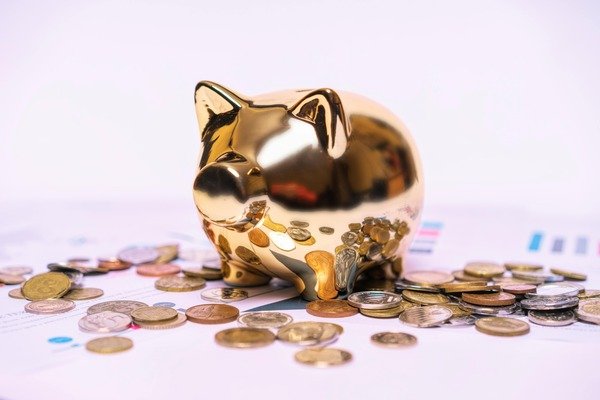 Coins scattered near a golden piggy bank