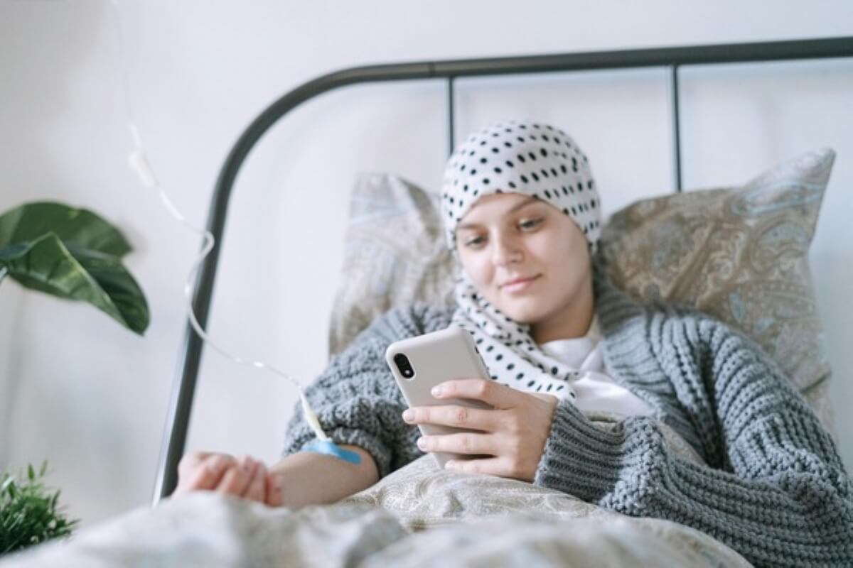 Patient receiving treatment at home while using a phone, showing how MediShield Life changes may affect care expenses.