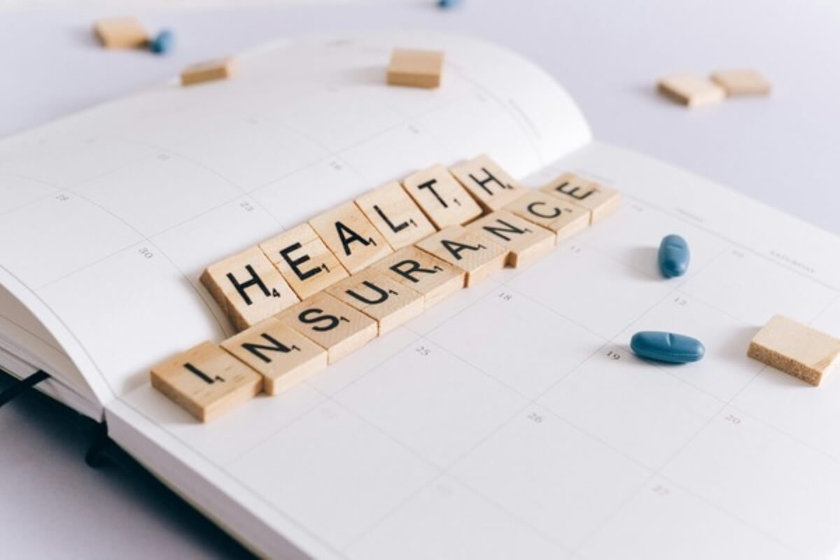 Health insurance tiles and medication on a planner, representing MediShield Life changes and healthcare budgeting.