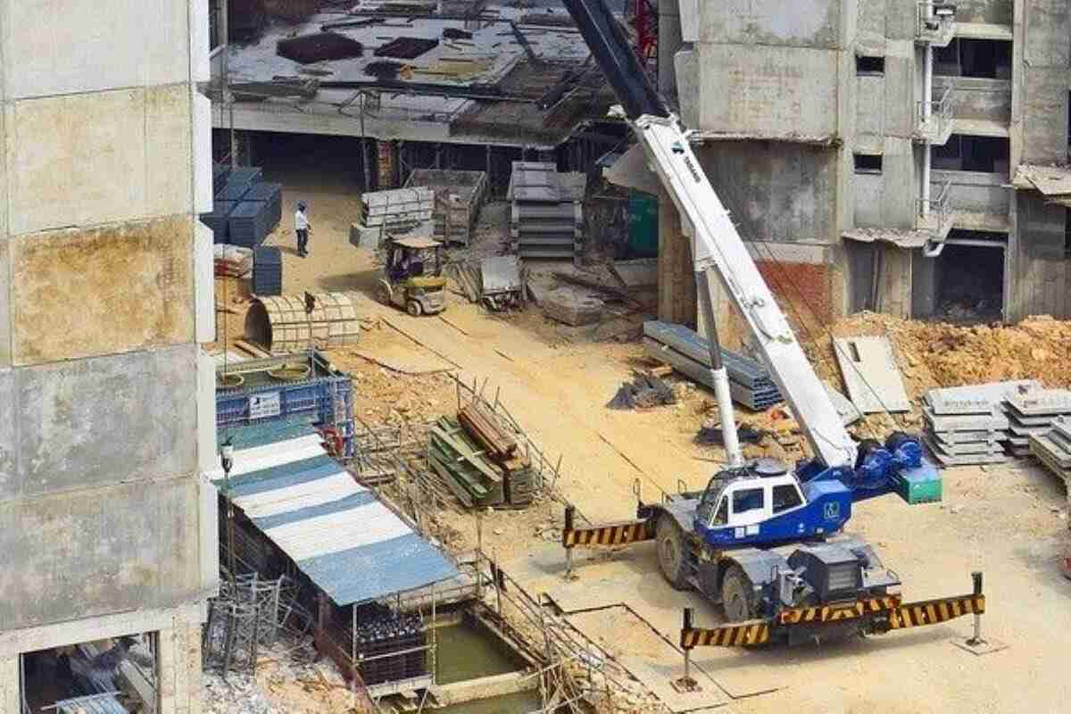 Construction site with heavy machinery and unfinished residential buildings, showing the development process when buying property under construction.