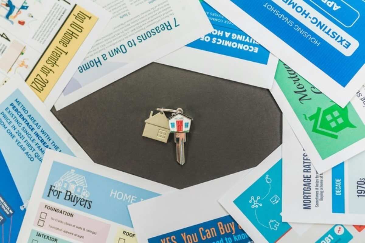 House keys placed on home buying guides and brochures, highlighting essential research before buying property under construction.