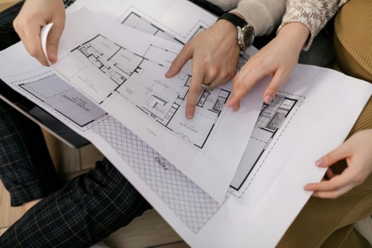 Homebuyers reviewing apartment floor plans together, comparing layouts before buying property under construction.