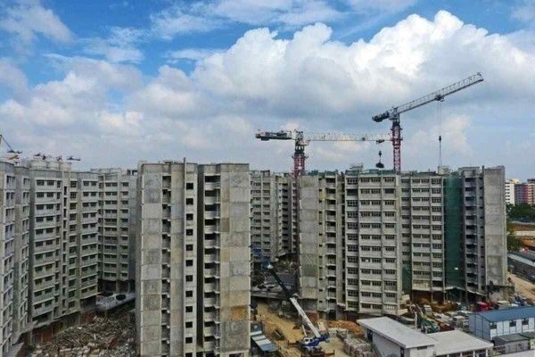 HDB blocks under construction with cranes overhead, illustrating the progress and risks of buying property under construction in Singapore.