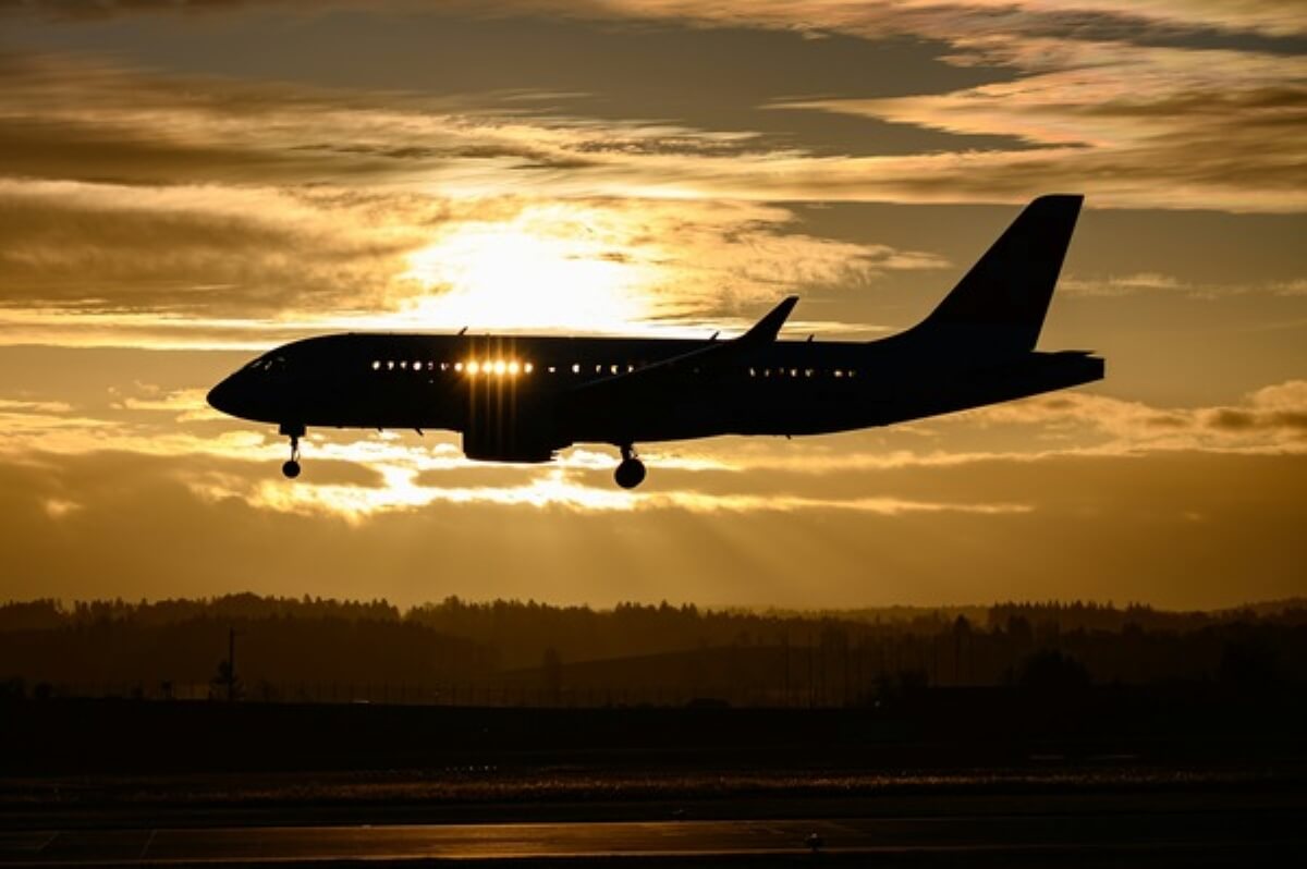 Passenger plane landing at sunset, symbolising flights booked through miles, rewards, or free travel programmes.