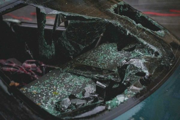 Close-up of a shattered car windscreen caused by an accident, illustrating Singapore car insurance coverage for windscreen repairs.