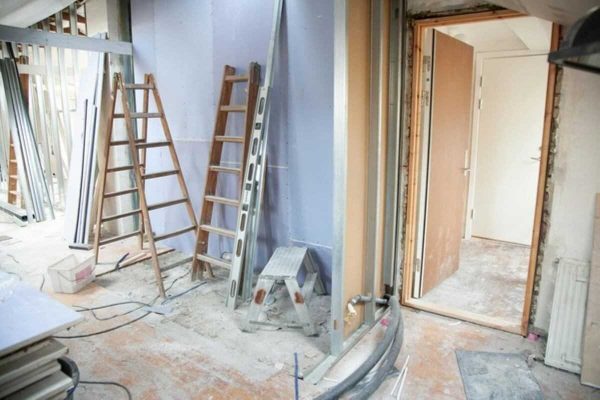 Unfinished flat interior with ladders and materials during an HDB renovation.