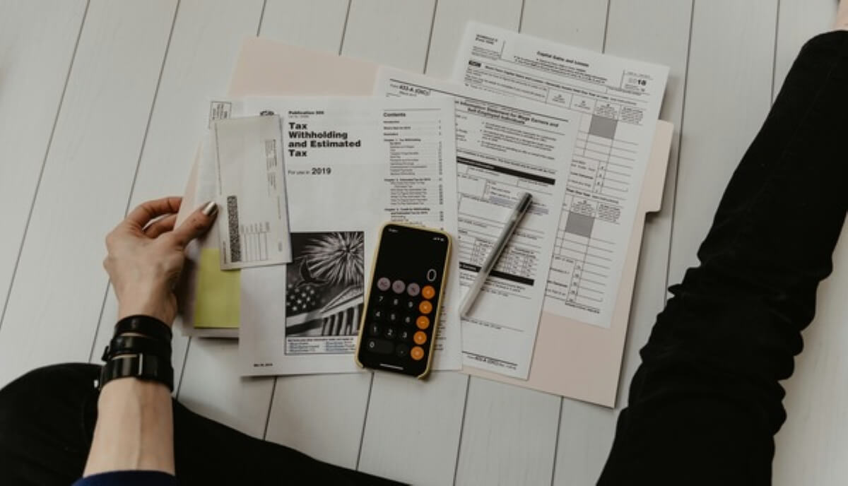 Tax documents, calculator and financial paperwork illustrating tax planning for employee stock options and equity compensation.