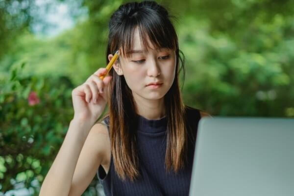 Young woman researching retirement planning and micro-retirement options on her laptop.