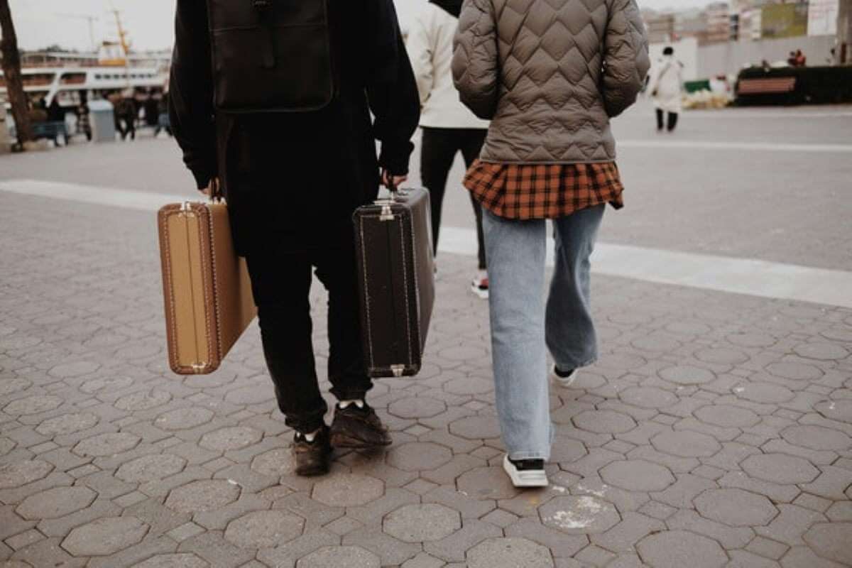 Travellers carrying suitcases during a planned micro-retirement career break.