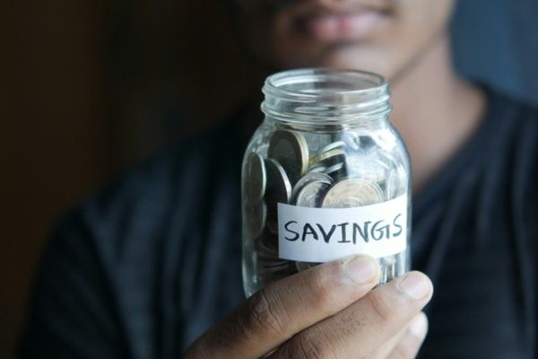 Person holding a savings jar to build retirement funds under cpf changes 2025