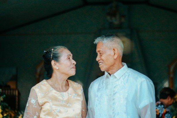 A photo of an elderly couple looking at each other and smiling