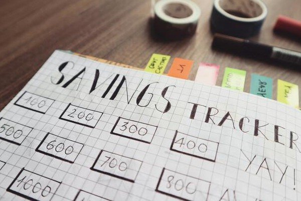 A close-up photo of a savings tracker placed on a wooden table