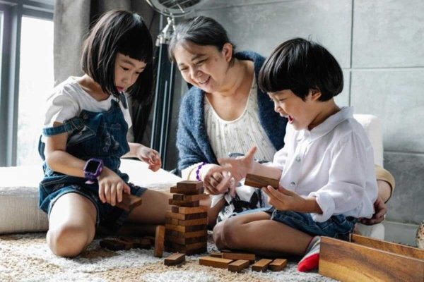 Grandmother playing with her grandchildren, showing how health insurance singapore helps protect families across generations.