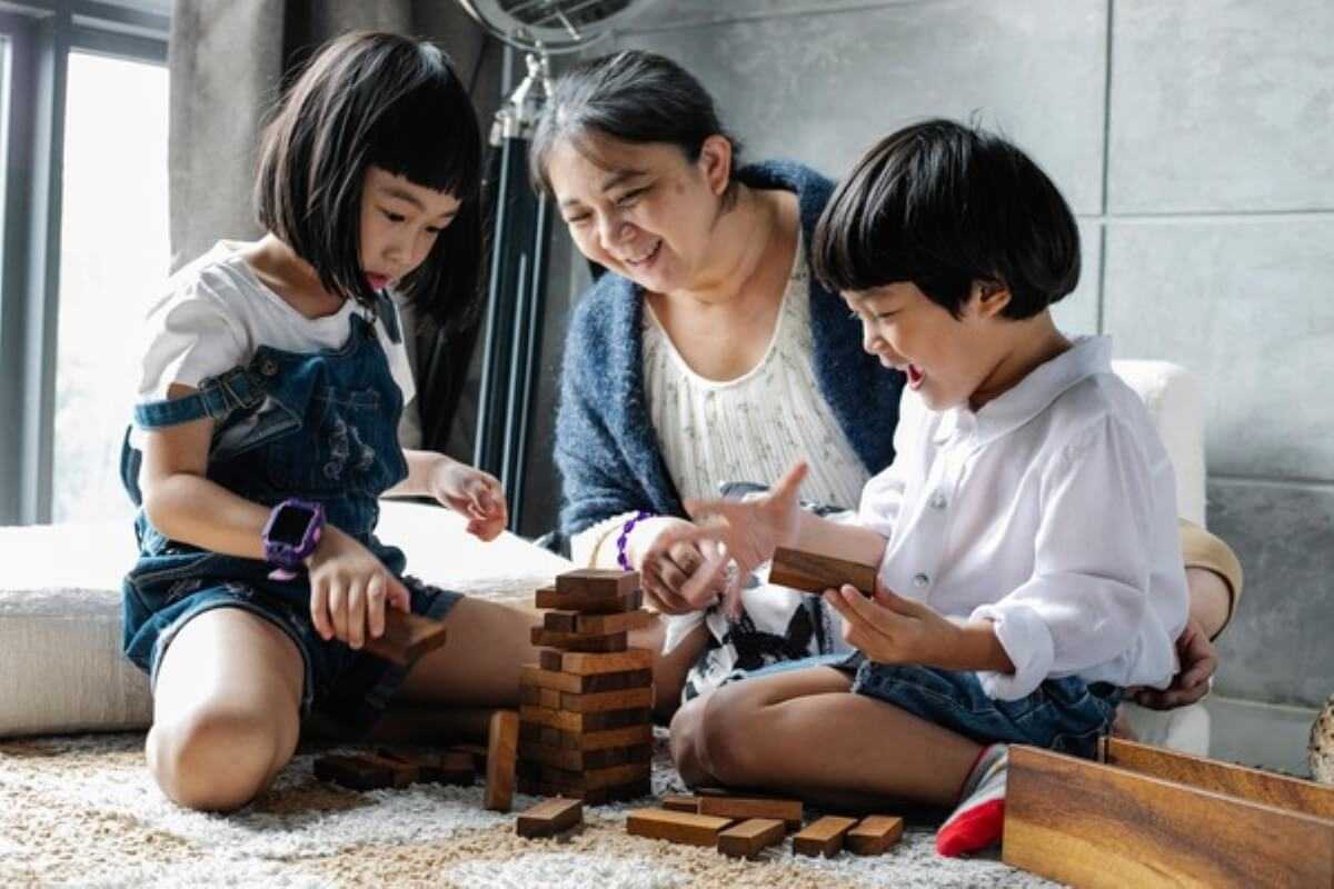 Grandmother playing with her grandchildren, showing how health insurance singapore helps protect families across generations.