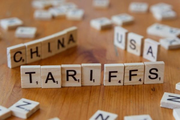 Wooden letter tiles spelling "China," "USA," and "Tariffs," illustrating the impact of trump tariff on global trade.
