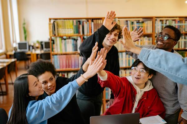 A photo of a group of people in the library giving high fives