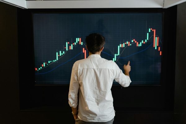 Investor analysing market charts to compare money market funds with other investment options.