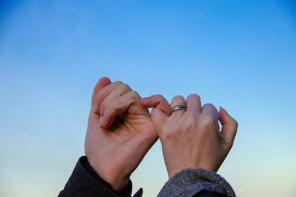 A photo of a two people's hands doing pinky swear